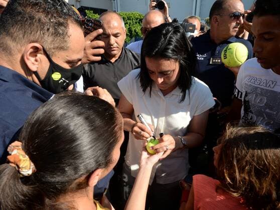 (220714) -- TUNIS, July 14, 2022 -- Ons Jabeur (C) signs autograph for fans after arriving in Tunis, Tunisia, July 13, 2022. Tunisian tennis player Ons Jabeur won the runner-up in the women s singles final at the 2022 Wimbledon tennis tournament in London, England, on July 9. (Photo by Adel Ezzine Xinhua) (SP)TUNISIA-TUNIS-TENNIS-ONS JABEUR HuangxLing 