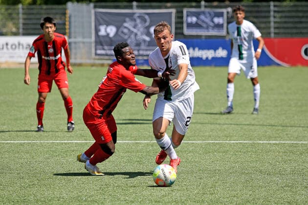 Derrick Kyere (KM) li. gegen Kushtrim Asallari (MG) re. Fussball Regionalliga West, 1. Spieltag, 1. FC Kaan-Marienborn - Borussia Moenchengladbach (U23), am 24.07.2022 in Siegen Deutschland.