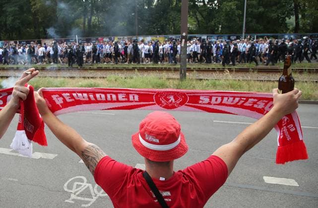 vorn Unionfan mit Schal: gewinnen sowieso, hinten Fanmarsch der Herthaner Herthafans zum Stadion an der Alten Försterei AF Fußball Fussball Bundesliga Herren DFL 1. Spieltag Saison 2022 2023 06.08.2022 1.FC Union Berlin FCU vs. Hertha BSC Berlin Stadtderby Ortsderby Derby DFL regulations prohibit any use of photographs as image sequences and or quasi-video.