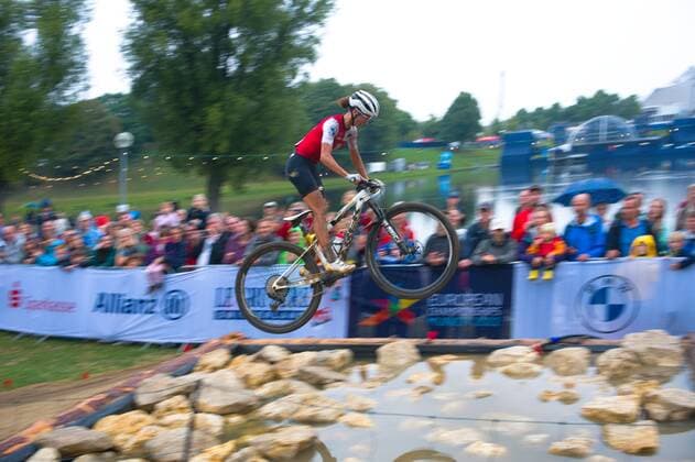 European Championships Munich 2022. Olympiaberg München, Mountainbike Rennen der Frauen Women Cross Country Finals. Jolanda Neff (SUI) wird Vierte, hier bei der Überquerung des Wassergrabens. *** European Championships Munich 2022 Olympiaberg Munich, Womens Mountain Bike Race Women Cross Country Finals Jolanda Neff SUI finishes fourth, here crossing the moat.