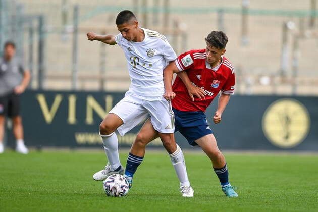 v.li.: Matteo Perez Vinlöf (FCB, 3) Florian Markert (Unterhaching, 6) im Zweikampf, Duell, duel, tackle, Dynamik, Action, Aktion, 21.08.2022, Unterhaching (Deutschland), Fussball, A-Junioren-Bundesliga Süd Südwest, SpVgg Unterhaching - FC Bayern München, DFB DFL REGULATIONS PROHIBIT ANY USE OF PHOTOGRAPHS AS IMAGE SEQUENCES AND OR QUASI-VIDEO.
