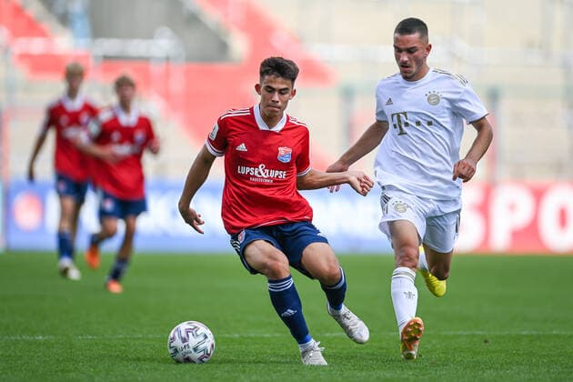 v.li.: Aaron Keller (Unterhaching, 10) Arjon Ibrahimovic (FCB, 10) im Zweikampf, Duell, duel, tackle, Dynamik, Action, Aktion, 21.08.2022, Unterhaching (Deutschland), Fussball, A-Junioren-Bundesliga Süd Südwest, SpVgg Unterhaching - FC Bayern München, DFB DFL REGULATIONS PROHIBIT ANY USE OF PHOTOGRAPHS AS IMAGE SEQUENCES AND OR QUASI-VIDEO.