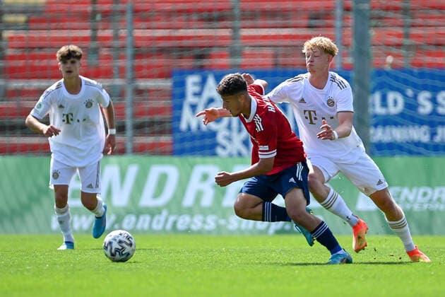 v.li.: Florian Markert (Unterhaching, 6) Lennard becker (FCB, 8) im Zweikampf, Duell, duel, tackle, Dynamik, Action, Aktion, 21.08.2022, Unterhaching (Deutschland), Fussball, A-Junioren-Bundesliga Süd Südwest, SpVgg Unterhaching - FC Bayern München, DFB DFL REGULATIONS PROHIBIT ANY USE OF PHOTOGRAPHS AS IMAGE SEQUENCES AND OR QUASI-VIDEO.