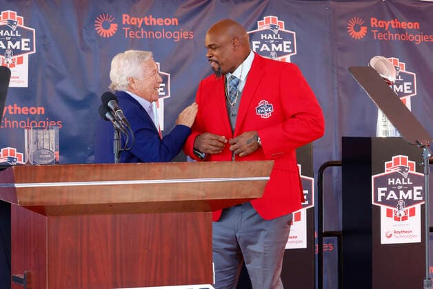FOXBOROUGH, MA - SEPTEMBER 24: New England Patriots chairman and CEO Robert Kraft helps New England Patriots nose tackle Vince Wilfork on with his red jacket during his induction into the New England Patriots Hall of Fame presented by Raytheon Technologies on September 24, 2022, at Gillette Stadium in Foxborough, Massachusetts. (Photo by Fred Kfoury III Icon Sportswire) NFL, American Football Herren, USA SEP 24 Vince Wilfork Induction Icon482220924020