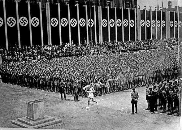 ARKIV 1936 OS-invigningen i Berlin 1936. För första gangen i historien fördes den olympiska elden i stafett fran Olympia i Grekland till Berlin. 28 000 fran Hitler-Jugend bildade spalje längs den sk Via Triumphalis fran Berlins centrum till Ridsportfältet invigningsdagen och avslutningsdagen. Den siste fackelbäraren är den tyske friidrottaren Fritz Schilgen. Opening ceremony for the olympics in Berlin.Torch-bearer is the german athlet Fritz Schilgen. Berlin TYSKLAND OS x1900x Copyright: xTTxHISTORICALx OS-invigningen 1936