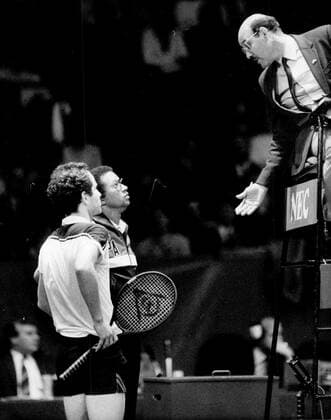 Göteborg 1984-12-18 Tennis, Davis Cup-final mellan Sverige och USA pa grus i Scandiavium. Spelaren John McEnroe och förbundskaptenen Arthur Ashe i samtal med domaren. Göteborg Sverige x12014x