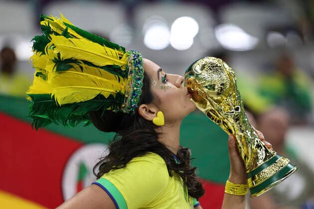 (221124) -- LUSAIL, Nov. 24, 2022 -- A fan kisses a replica of the World Cup trophy before the Group G match between Brazil and Serbia at the 2022 FIFA World Cup, WM, Weltmeisterschaft, Fussball at Lusail Stadium in Lusail, Qatar, Nov. 24, 2022. ) (SP)QATAR-LUSAIL-FOOTBALL-2022 WORLD CUP-GROUP G-BRA VS SRB XuxZijian 