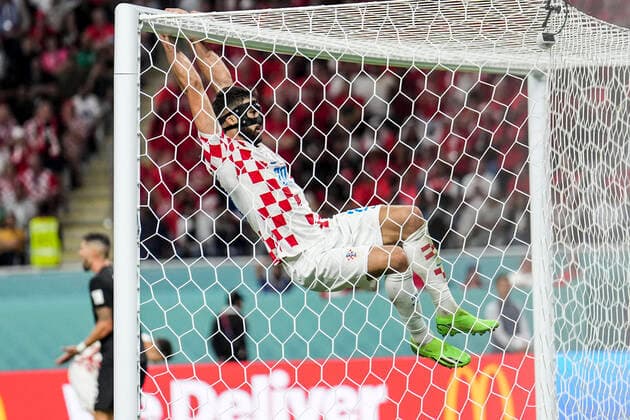 (221127) -- DOHA, Nov. 27, 2022 -- Josko Gvardiol (Top) of Croatia hangs off the crossbar during the Group F match between Croatia and Canada at the 2022 FIFA World Cup, WM, Weltmeisterschaft, Fussball at Khalifa International Stadium in Doha, Qatar, Nov. 27, 2022. ) (SP)QATAR-DOHA-2022 WORLD CUP-GROUP F-CRO VS CAN MengxDingbo 