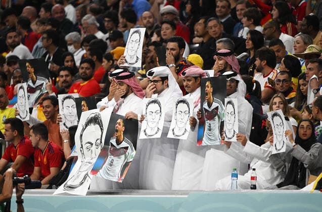 Fussball, Herren, Saison 2022 23, WM in Katar, Gruppe E (2. Spieltag), Spanien - Deutschland im Al-Bayt Stadium in Al-Khor, Protestaktion von Katarern, sie zeigen Bilder von Mesut Özil und halten sich den Mund zu, diese Geste verwendeten die Spieler der deutschen Nationalmannschaft vor dem ersten Gruppenspiel gegen Japan als Protest, 27.11. 2022, *** Football, Men, 2022 23 season, World Cup in Qatar, Group E 2 match day , Spain Germany at Al Bayt Stadium in Al Khor, protest action by Qataris, they show pictures of Mesut Özil and cover their mouths, this gesture was used by the players of the German national team as a protest before the first group match against Japan, 27 11 2022, Copyright: xMatthiasxKochx