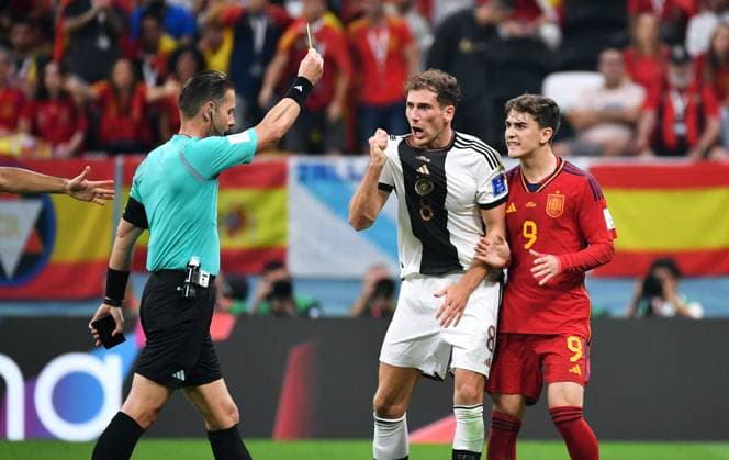Fussball, Weltmeisterschaft, 2022, Herren, Qatar, Gruppe E, 2. Spieltag, Al Bayt Stadium: Spanien - Deutschland 1:1; Schiedsrichter Danny Makkiele (NED) zeigt Leon Goretzka (GER) die gelbe Karte nach Foul an Gavi (SPA). Aktion FIFA REGULATIONS PROHIBIT ANY USE OF PHOTOGRAPHS AS IMAGE SEQUENCES AND OR QUASI-VIDEO *** Football, World Cup, 2022, Men, Qatar, Group E, Matchday 2, Al Bayt Stadium Spain Germany 1 1 Referee Danny Makkiele NED shows Leon Goretzka GER the yellow card after foul on Gavi SPA Action FIFA REGULATES PROHIBIT ANY USE OF PHOTOGRAPHS AS IMAGE SEQUENCES AND OR QUASI VIDEO
