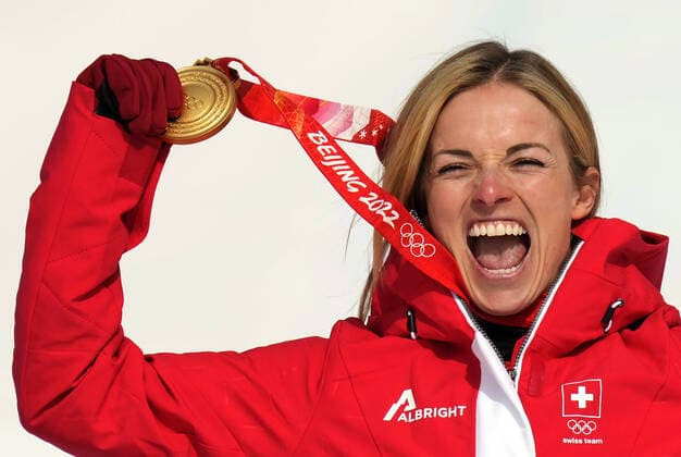 Lara Gut-Behrami of Switzerland shows off her gold medal in women s Super-G at the Winter Olympics in Beijing on Friday, February 11, 2022.  POY2022S091 RICKxTxWILKING