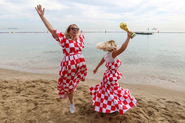 Croatian fans unfurled giant flag - FIFA World Cup, WM, Weltmeisterschaft, Fussball Qatar 2022 Two Croatian fans dancing with FIFA World Cup Trophy on the beach in front of the Hilton Doha Hotel ahead of the match against Belgium in Doha, Qatar, on December 01, 2022. IgorxKralj PIXSELL