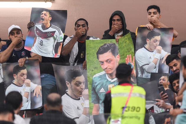 FUSSBALL WM 2022 VORRUNDE GRUPPE E Costa Rica - Deutschland 01.12.2022 Zuschauer aus Katar halten sich den Mund zu und halten Plakate auf denen Mesut Oezil zu sehen ist in die Höhe. *** FOOTBALL WORLD CUP 2022 PRE-ROUND GROUP E Costa Rica Germany 01 12 2022 Qatar spectators cover their mouths and hold up posters showing Mesut Oezil