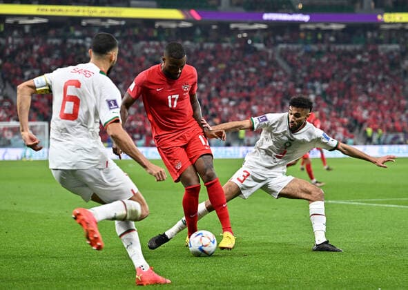 (221201) -- DOHA, Dec. 1, 2022 -- Cyle Larin (C) of Canada vies with Noussair Mazraoui of Morocco during their Group F match at the 2022 FIFA World Cup, WM, Weltmeisterschaft, Fussball at Al Thumama Stadium in Doha, Qatar, Dec. 1, 2022. ) (SP)QATAR-DOHA-2022 WORLD CUP-GROUP F-CAN VS MAR XinxYuewei 