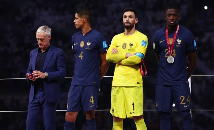 Doha, Qatar, 18th December 2022. Didier Deschamps coach of France looks at his loosers medal as Raphael Varane, Hugo Lloris and Ibrahima Konate of France stand around dejected during the FIFA World Cup, WM, Weltmeisterschaft, Fussball 2022 match at Lusail Stadium, Doha. Picture credit should read: David Klein Sportimage EDITORIAL USE ONLY. No use with unauthorised audio, video, data, fixture lists, club league logos or live services. Online in-match use limited to 120 images, no video emulation. No use in betting, games or single club league player publications. SPI-2101-0233