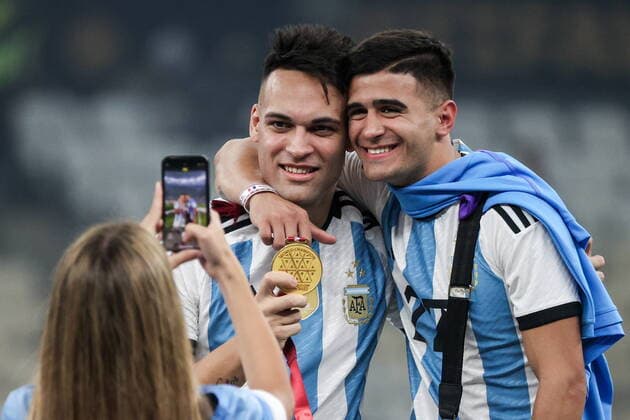 QATAR, LUSAIL - DECEMBER 18, 2022: Argentina s player Lautaro Martinez (L back) and a fan pose for a photograph celebrate with the trophy after the trophy ceremony for the 2022 FIFA World Cup, WM, Weltmeisterschaft, Fussball final football match between Argentina and France at Lusail Iconic Stadium. Argentina won 3-3 (4-2) in a penalty shootout. Sergei Bobylev TASS  56489628