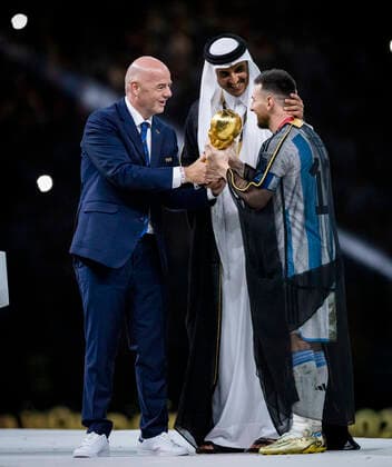 Doha, Qatar. 18th Dec, 2022. Lionel Messi of Argentina carries the FIFA World Cup, WM, Weltmeisterschaft, Fussball Qatar 2022 Winner s Trophy as Gianni Infantino, President of FIFA, and Sheikh Tamim bin Hamad Al Thani, Emir of Qatar, look on during the FIFA World Cup Qatar 2022 Final match between Argentina - France Final Match Argentinien - Frankreich World Cup 2022 in Qatar 18.12.2022