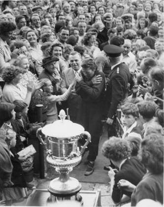 Greta Andersen Greta Andersen protects herself from the pats on the back from the crowd as she is escorted by Billy Butlin to receive her trophy after winning the Cross Channel swimming race. 21st August 1957 Denmark  Copyright: xTopFotox 0750073
