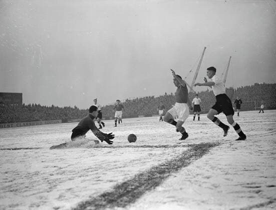 FOOTBALL STUDY- IN BLACK AND WHITE Sliding to his knees in the snow , Ian BLACK , Fulham s goalkeeper , shoots out ready hands to take the ball from the rushing Manchester United, ManU centre-forward John ASTON in the First Division match at Craven Cottage ground , London . Aston England international full-back , was playing at centre forward in the absence of Rowley, helped his team to a 2-2 draw against Fulham . 16 December 1950 United Kingdom England  Copyright: xTopFotox 2001893