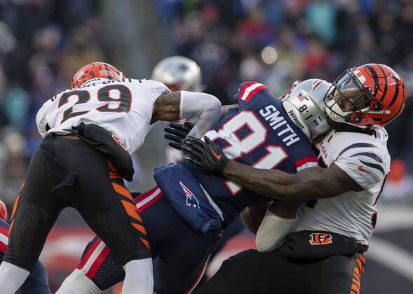 New England Patriots tight end Jonnu Smith (81) is shoved into Cincinnati Bengals linebacker Germaine Pratt (57) by cornerback Cam Taylor-Britt (29) during the second half of a game at Gillette Stadium in Foxborough, Massachusetts on Saturday, December 24, 2022.  BOS20221224120