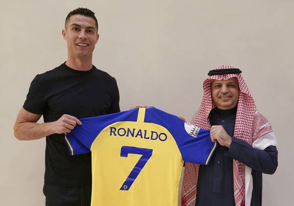 Cristiano Ronaldo (L) holds a team jersey of Saudi Arabian club Al Nassr with his name and No. 7 on it, in Madrid, Spain on Friday, December 30, 2022. Ronaldo has signed with the Saudi Arabian club in a deal worth a reported $200 million.  SBN2022123103 AlxNassrxFC