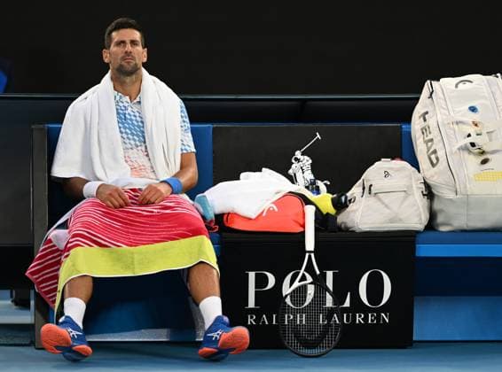 TENNIS AUSTRALIAN OPEN, Novak Djokorvic of Serbia waits as Enzo Couacaud of France receives medical attention during their second round match at the 2023 Australian Open tennis tournament at Melbourne Park in Melbourne, Thursday, January 19, 2023. ( NO ARCHIVING, EDITORIAL USE ONLY, NO USE IN BOOKS WITHOUT CONSENT MELBOURNE VICTORIA AUSTRALIA  Copyright: xLUKASxCOCHx 20230119001754280030