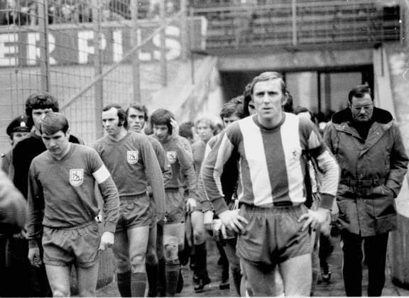 Wuppertaler SV - Eintracht Braunschweig 2:1 17.03.1973 Die Mannschaften kommen aufs Feld. Vorne die Kaptäne Manfred Reichert (Wuppertaler SV, links) und Peter Kaack (Eintracht Braunschweig), ganz rechts Trainer Otto Knefler (Eintracht)