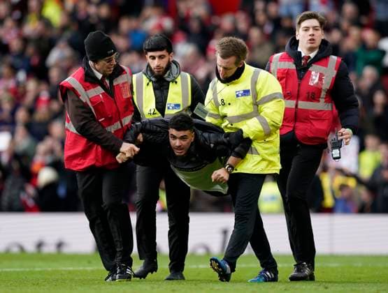 Sport Themen der Woche KW07 Sport Bilder des Tages Manchester, England, 19th February 2023. A fan is caught as he enters the pitch at the end of the game during the Premier League match at Old Trafford, Manchester. Picture credit should read: Andrew Yates Sportimage EDITORIAL USE ONLY. No use with unauthorised audio, video, data, fixture lists, club league logos or live services. Online in-match use limited to 120 images, no video emulation. No use in betting, games or single club league player publications. SPI-2247-0078