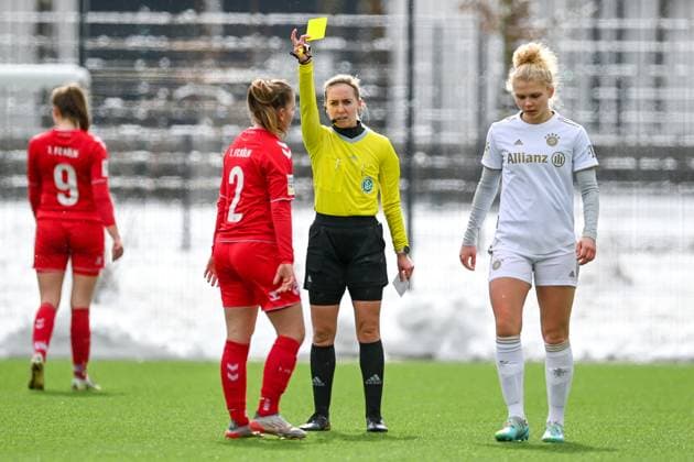 Julia Boike (Schiedsrichterin) zeigt Antonia Langshausen (Köln, 2) die Gelbe Karte, Verwarnung, yellow card, 26.02.2023, München (Deutschland), Fussball,2. Frauen-Bundesliga, FC Bayern München II - 1. FC Köln II, DFB DFL REGULATIONS PROHIBIT ANY USE OF PHOTOGRAPHS AS IMAGE SEQUENCES AND OR QUASI-VIDEO.