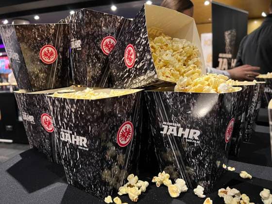 Popcorn im Design des Pokals der Europa League im Kino bei der Filmpremiere - Frankfurt 08.03.2023: Filmpremiere In diesem Jahr von Eintracht Frankfurt