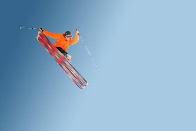 Stylish skier in orange jacket cap and sunglasses in jump does the trick isolated on a blue gradient background Stylish skier in orange jacket cap and sunglasses in jump does the trick isolated on a blue gradient background. (License=RF) 18120545 ,model released, Symbolfoto Copyright: xZoonar.com IanxIankovskiix 18120545 ,model released, Symbolfoto ,property released