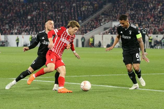 16.03.2023, xtvx, Fussball UEFA Europa League 1 8 Finale, SC Freiburg - Juventus Turin emspor, v.l. Filip Kostic (Juventus Turin) Ritsu Doan (SC Freiburg) Danilo (Juventus Turin) Zweikampf, Aktion, action, battle for the ball (DFL DFB REGULATIONS PROHIBIT ANY USE OF PHOTOGRAPHS as IMAGE SEQUENCES and or QUASI-VIDEO) Freiburg
