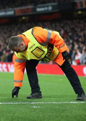 Arsenal v Sporting 16 March 2023, London - UEFA EUROPA League Football - Round of 16, 2nd Leg - Arsenal v Sporting Clube de Portugal - A steward picks up debris off the pitch that was thrown by Sporting fans - Photo: Charlotte Wilson Offside. London UK Copyright: xCharlottexWilsonx xOffsidexOffside