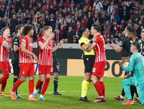16.03.2023; Freiburg im Breisgau, Baden Württemberg, Deutschland, Europa Schrecksekunde: Michael Gregoritsch (SC Freiburg 38) packt, greift, umarmt Schiedsrichter Serdar Gözübüyük (Niederlande) Mitspieler schauen verdutzt, verwirrt, irritiert vl. Manuel Locatelli (Juventus Turin 5) Kiliann Sildillia (SC Freiburg 25) Matthias Ginter (SC Freiburg 28) vr. Torhüter Wojciech Szczesny (Juventus Turin 1) Gleison Bremer Silva Nascimento (Juventus Turin 3) Fussball UEFA Europa League 2022 2023: Achtelfinale Rückspiel - SC Freiburg - Juventus Turin, im Europa Park Stadion
