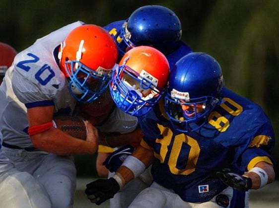 Prep football. -- (Please don t crop. Thanks) -- Photo1 - Good thing Osceola High School quarterback Ben Paul s, ( 22, cq by roster), head wasn t in his helmet, center, when it got sandwiched between the hard hits of teammate Steve Williams, ( 20, cq by roster), left, and Largo High School s Grant Scelzi ( 80, cq by roster), right, during first quarter play Thursday - ZUMAs70_ - ZUMA2 0073529212st Copyright: ximagoxstock&peoplex