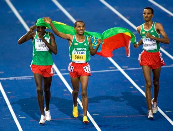 Berlin, Germany. Ethiopian athlete Deriba Merga, Kenenisa Bekele, who won the 5000 metres men s running event, and Gebregziabher Gebremariam (L-R) run with the Ethiopian flag during the 2009 World Championships in Athletics at the Olympiastadion. Robert Maximov TASS  58332674