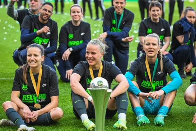 18.05.2023, GER, Fußball, DFB-Pokal-Finale der Frauen 2022 2023, VfL Wolfsburg - SC Freiburg Joelle Wedemeyer (links, Wolfsburg), Pia-Sophie Wolter (Mitte, Wolfsburg) und Merle Frohms (1 Wolfsburg) sitzen mit dem Pokal auf dem Rasen. Köln RheinEnergieSTADION Nordrhein-Westfalen Deutschland
