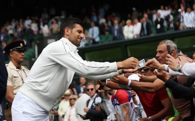 Serbian Novak Djokovic signs autographs after his first round victory against Argentina s Pedro Cachin on day one of the 2023 Wimbledon championships in London on Monday, July 03, 2023.  LON2023070339 HUGOxPHILPOTT