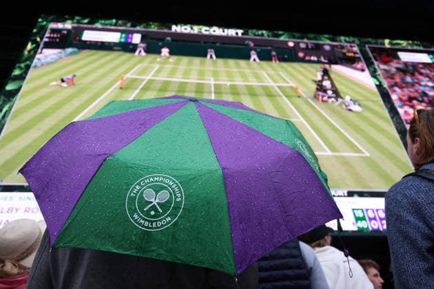 Sport Bilder des Tages Wimbledon: Day Two 4 July 2023, Wimbledon - Wimbledon Tennis Championships - Day Two - Spectators get shelter under an umbrella - Photo: Charlotte Wilson Offside . Wimbledon UK Copyright: xCharlottexWilsonx xOffsidexOffside