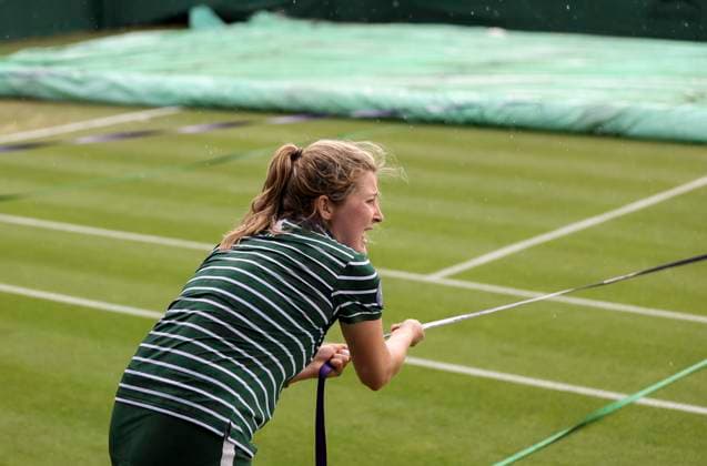(230705) -- LONDON, July 5, 2023 -- A ground staff pulls the rain cover to protect the grass court at the beginning of the rain delay during the women s singles first round match between Zhang Shuai of China and Donna Vekic of Croatia at Wimbledon Tennis Championships in London, Britain, July 5, 2023. ) (SP)BRITAIN-LONDON-TENNIS-WIMBLEDON-DAY 3 HanxYan 