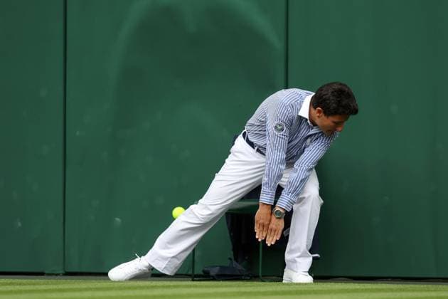 Wimbledon: Day Three 5 July 2023, Wimbledon - Wimbledon Tennis Championships - Day Three - A line judge moves to avoid the ball as it slams into the green backing - Photo: Charlotte Wilson Offside . Wimbledon UK Copyright: xCharlottexWilsonx xOffsidexOffside