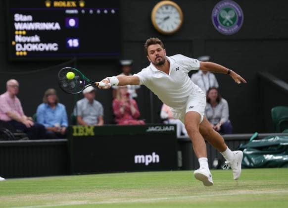 Swiss Stan Wawrinka plays a forehand in his third round match against Serbian Novak Djokovic on day five of the 2023 Wimbledon championships in London on Friday, July 07, 2023.  LON2023070782 HUGOxPHILPOTT