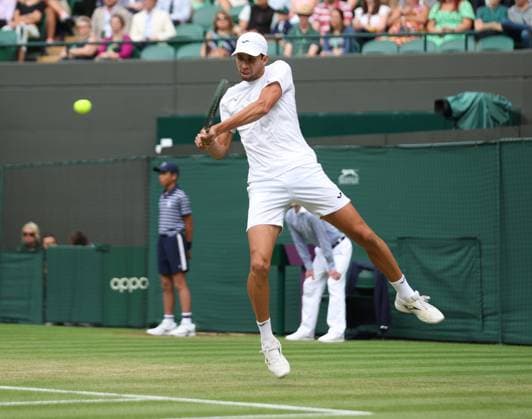 Columbia s Daniel Elah Galan plays a backhand in his match against Italy s Jannik Sinner on day seven of the 2023 Wimbledon championships in London on Sunday, July 9, 2023.  LON2023070910 HUGOxPHILPOTT