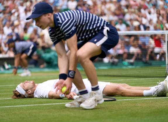 Sport Bilder des Tages 2023 Wimbledon Championships Andrey Rublev (RUS) stretched out on the grass after falling as a ball boy gathers the balls in his match against Novak Djokovic (SRB) on Number 1 court in the mens singles quarter finals on Day 9 at the 2023 Wimbledon Championships at the All England Club, London, UK, 11 July 2023, Credit:Peter van den Berg Avalon United Kingdom, England, London, All England Lawn Tennis and Croquet Club  Copyright: xPeterxvanxdenxBergx xAvalonx 0788556611