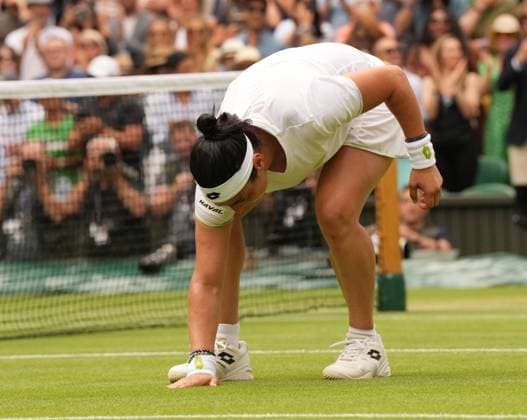 Tennis - 2023 Wimbledon Championships - Week Two - Day Ten - All England lawn Tennis & Racquet Club, Wimbledon - Wednesday 12th Ladies singles - Ons Jabeur (TUN) v Elena Rybakina (KAZ) Ons Jabeur touches the grass after her victory 