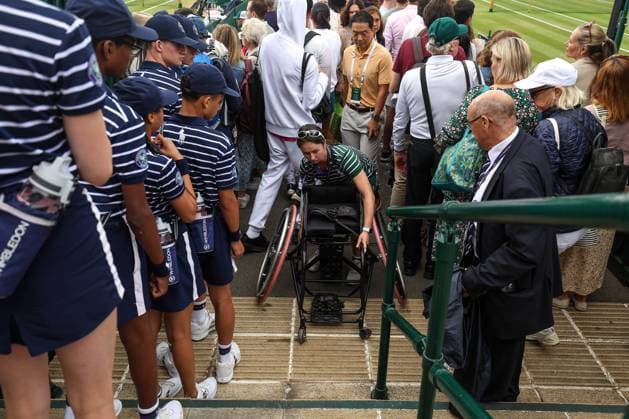Wimbledon: Day Eleven 13 July 2023, Wimbledon - Wimbledon Tennis Championships - Day Eleven - A member of ground staff brings a competitor™s wheelchair up the stairs - Photo: Charlotte Wilson Offside. Wimbledon UK Copyright: xCharlottexWilsonx xOffsidexOffside