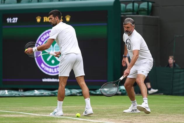 Wimbledon: Day Twelve 14 July 2023, Wimbledon - Wimbledon Tennis Championships - Day Twelve - Coach Goran Ivanisevic reaches for the ball as Novak Djokovic practises serving - Photo: Charlotte Wilson Offside. Wimbledon UK Copyright: xCharlottexWilsonx xOffsidexOffside