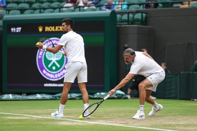 Wimbledon: Day Twelve 14 July 2023, Wimbledon - Wimbledon Tennis Championships - Day Twelve - Coach Goran Ivanisevic reaches for the ball as Novak Djokovic practises serving - Photo: Charlotte Wilson Offside. Wimbledon UK Copyright: xCharlottexWilsonx xOffsidexOffside