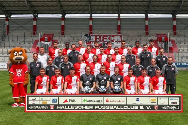 Teampraesentation Halle 3. Liga Hallescher FC, 3. Liga, Porträttermin 2023 2024, Mannschaftsfoto , Halle, 13.07.2021, Leuna-Chemie-Stadion, Fussball , 4. Reihe von links: Niklas Kreuzer, Erich Berko, Jannes Vollert, Tom Baumgart, Tunay Deniz, Andor Bolyki, Enrique Lofolomo, Yordi Wegmann , 3. Reihe von links: Sportdirektor Thomas Sobotzik, Technische Mitarbeiterin Sandra Schultze, Mannschaftsleiter Mario Nickeleit, Niklas Landgraf, Timur Gayret, Dominic Baumann, Mannschaftsarzt Dr. Thomas Bartels, Mannschaftsarzt Dr. Kenny Haase, Physiotherapeut Denis Hasenbek , 2. Reihe von links: Maskottchen Hallotri, Trainer Sreto Ristic, Co-Trainer Sergio Pinto, Torwarttrainer Marian Unger, Alexander Winkler, Jonas Nietfeld, Aljaz Casar, Tim-Justin Dietrich, Chefscout Fabio Leutenecker, Konditionstrainer John Brandes, Physiotherapeut Walter Moissejenko, 1. Reihe von links: Nico Hug, Besar Halimi, Matthew Meier, Torhüter Moritz Schulze, Torwart Sven Müller Mueller, Torwart Luca Bendel, Lucas Halangk, Henry Jon Crosthwaite, Leon Damer ,