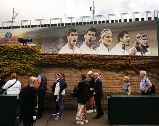 Tennis - 2023 Wimbledon Championships - Week Two - Day Thirteen - All England lawn Tennis & Racquet Club, Wimbledon -Saturday 15th Ladies final - Marketa Vondrousova (CZE) v Ons Jabeur Spectators queue outside Wimbledon in front of the players poster 